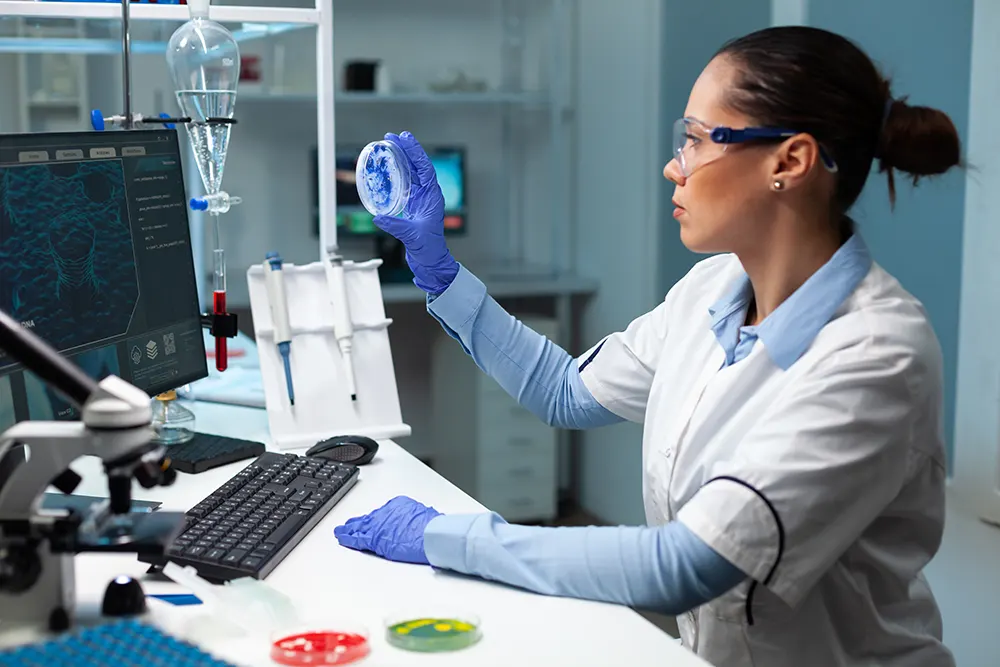 biologist-researcher-woman-holding-transparent-petri-dish-analyzing-blue-solutionwebp